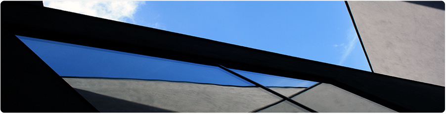 Arkitekturfoto: Gespiegelnde Hauswand und blauer Himmel.